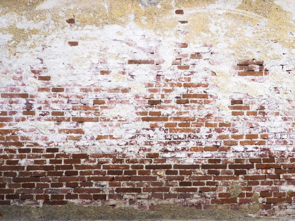 Osad wapienny na murze z cegły.